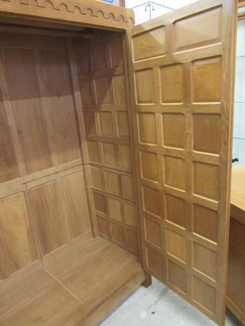 A ROBERT THOMPSON ADZED OAK DOUBLE WARDROBE of multi-panelled form with half penny moulded cornice Image