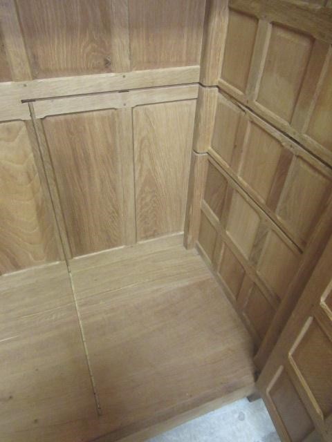A ROBERT THOMPSON ADZED OAK DOUBLE WARDROBE of multi-panelled form with half penny moulded cornice Image