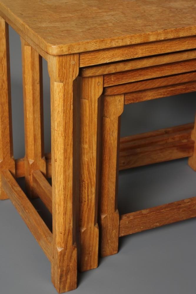 A ROBERT THOMPSON ADZED OAK NEST OF THREE TABLES Image