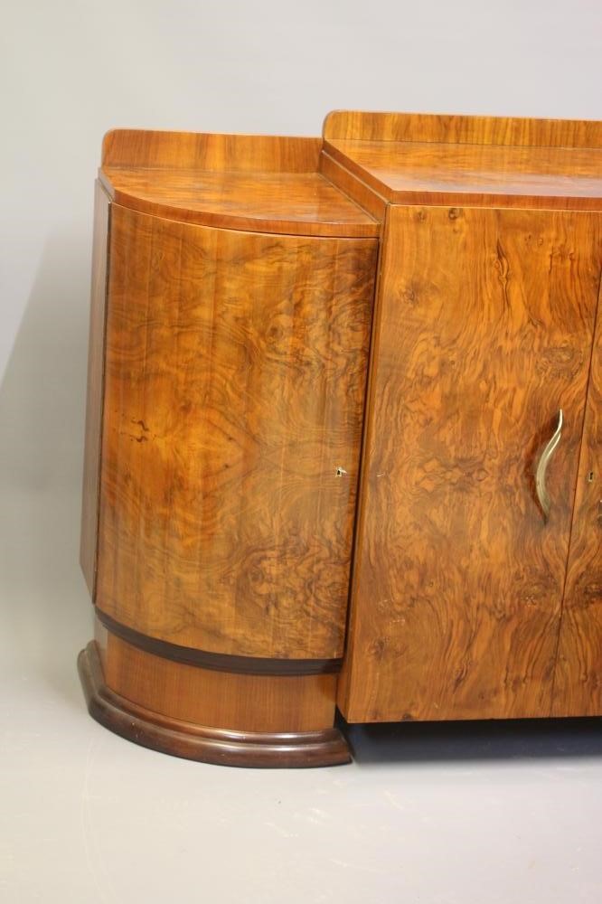 AN ART DECO WALNUT DINING SUITE comprising a draw leaf table with well figured oblong top Image