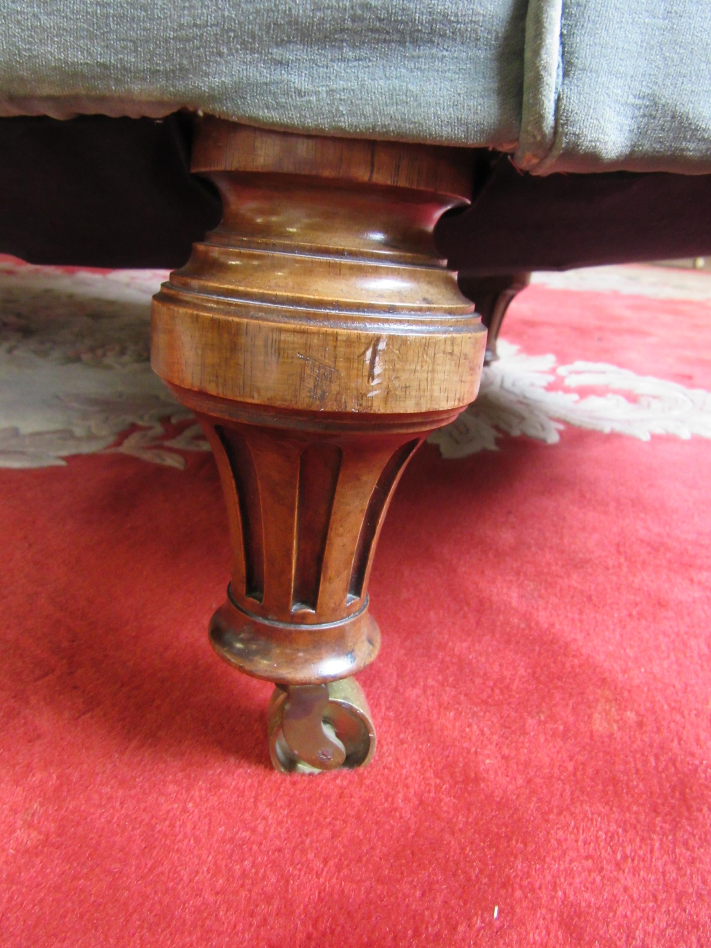 A VICTORIAN WALNUT FRAMED CHESTERFIELD SOFA of curved outline button upholstered in pale green Image