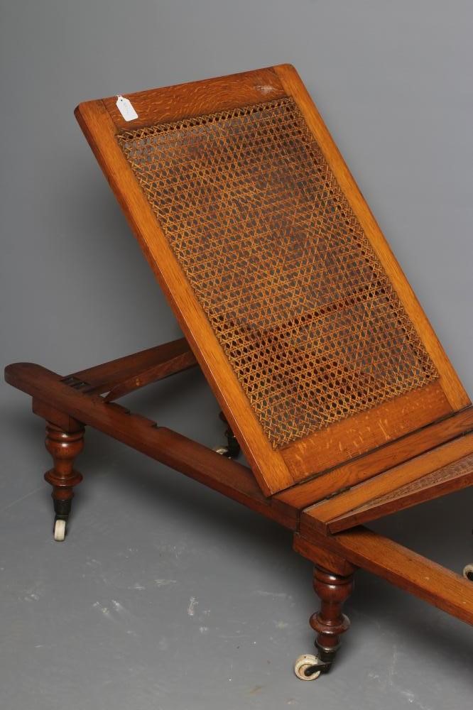 A VICTORIAN ROBINSONS OAK "ILKLEY COUCH" in the campaign style with adjustable caned panels Image