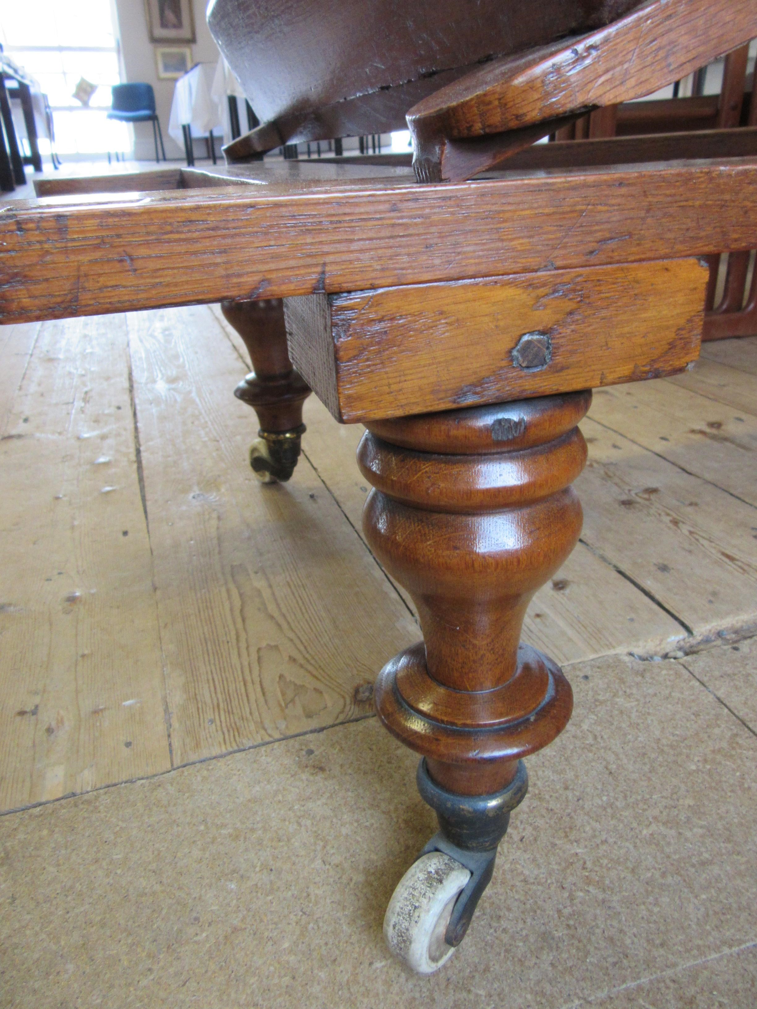 A VICTORIAN ROBINSONS OAK "ILKLEY COUCH" in the campaign style with adjustable caned panels Image