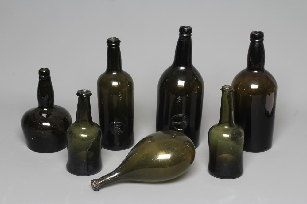SEVEN GREEN GLASS BOTTLES including a wine bottle with a griffin seal Image