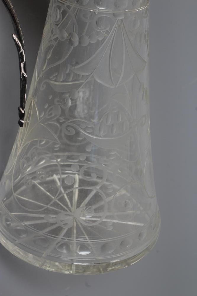 AN ELIZABETH II SILVER MOUNTED GLASS CLARET JUG of swept cylindrical form Image