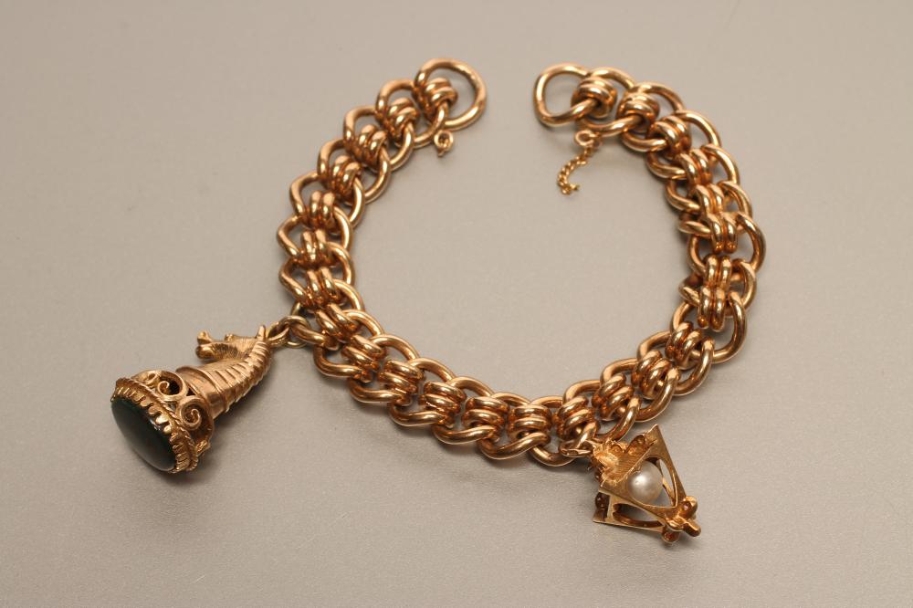 A 9CT GOLD FANCY LINK BRACELET hung with a bloodstone seal and a pearl set "street lamp" charm Image