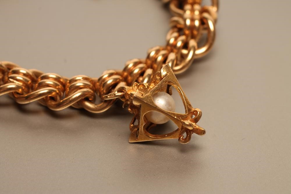 A 9CT GOLD FANCY LINK BRACELET hung with a bloodstone seal and a pearl set "street lamp" charm Image