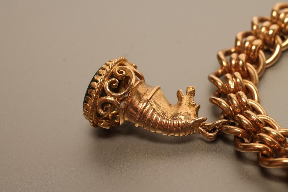 A 9CT GOLD FANCY LINK BRACELET hung with a bloodstone seal and a pearl set "street lamp" charm Image