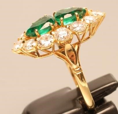 AN EMERALD AND DIAMOND MARQUISE SHAPE CLUSTER RING Image
