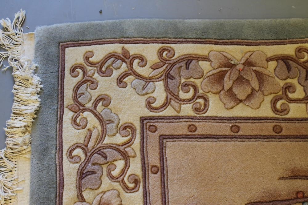 A CHINESE PICTORIAL WASHED AND FRINGED SILK RUG Image