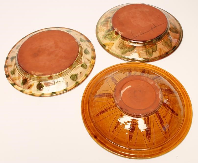 THREE STUDIO TERRACOTTA CHARGERS of plain dished circular form with scraffito type decoration of a Image