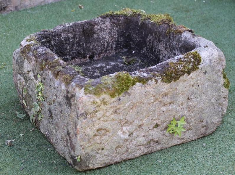 A SANDSTONE TROUGH of rough hewn irregular square form with one sloping side Image