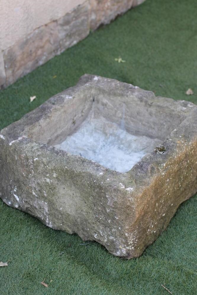 A SANDSTONE TROUGH of rough hewn square form Image