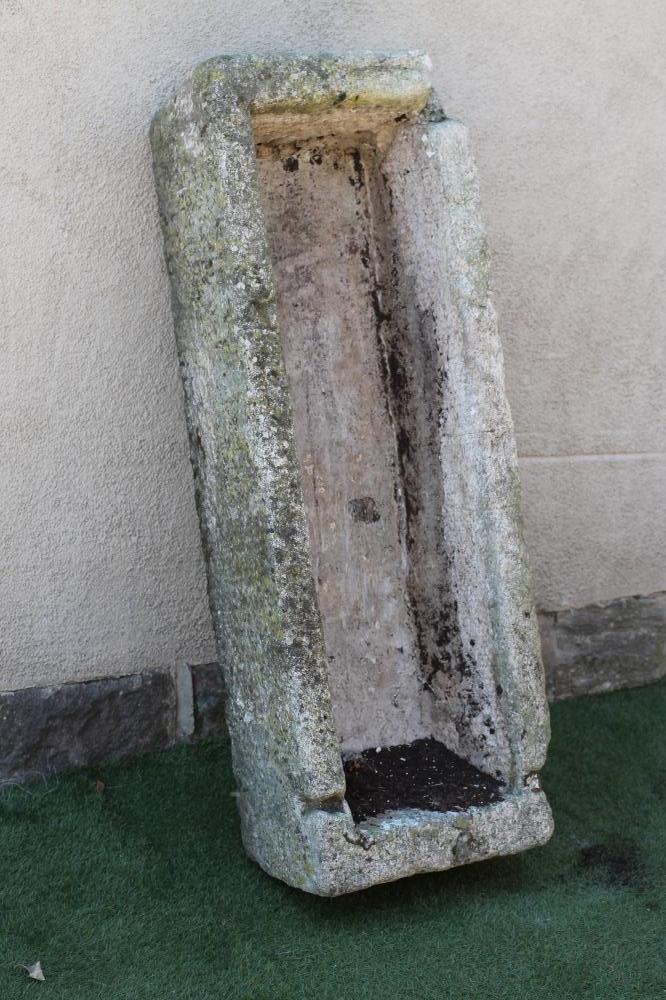 A LARGE GRANITE TROUGH of rough hewn narrow oblong form with mildly tapering sides Image