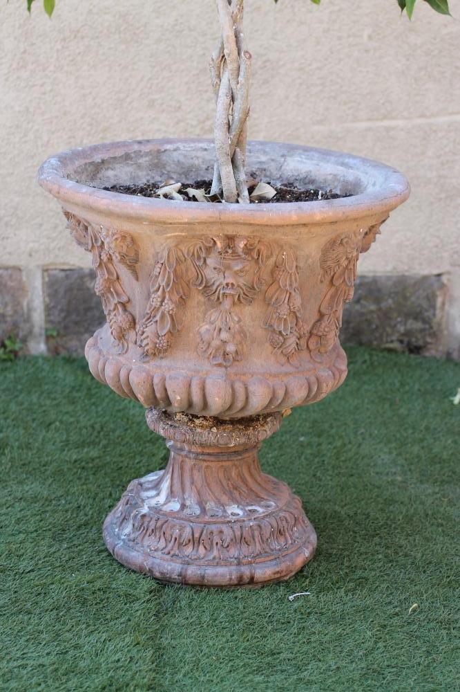 A TERRACOTTA URN of half fluted campana form Image