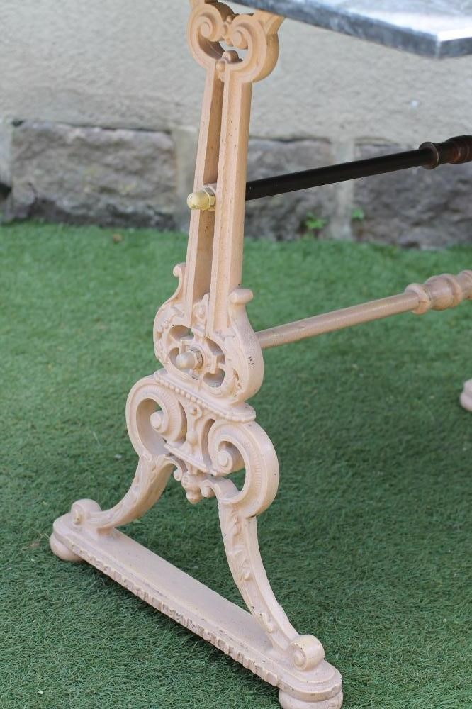A GARDEN TABLE comprising a veined grey marble top on a Victorian cast iron base Image
