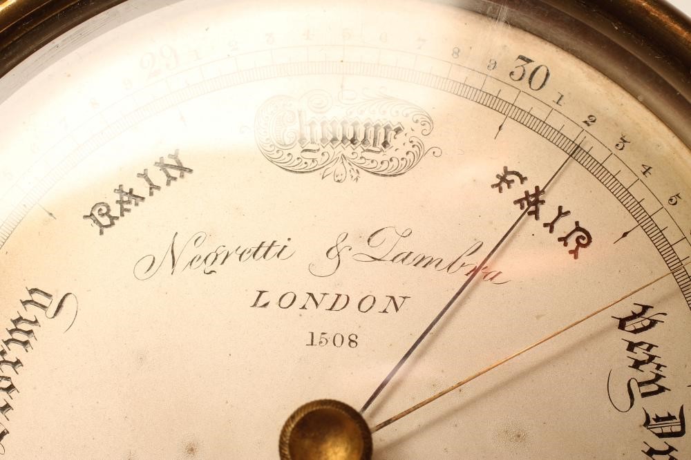 A BRASS CASED ANEROID BAROMETER by Negretti & Zambra Image