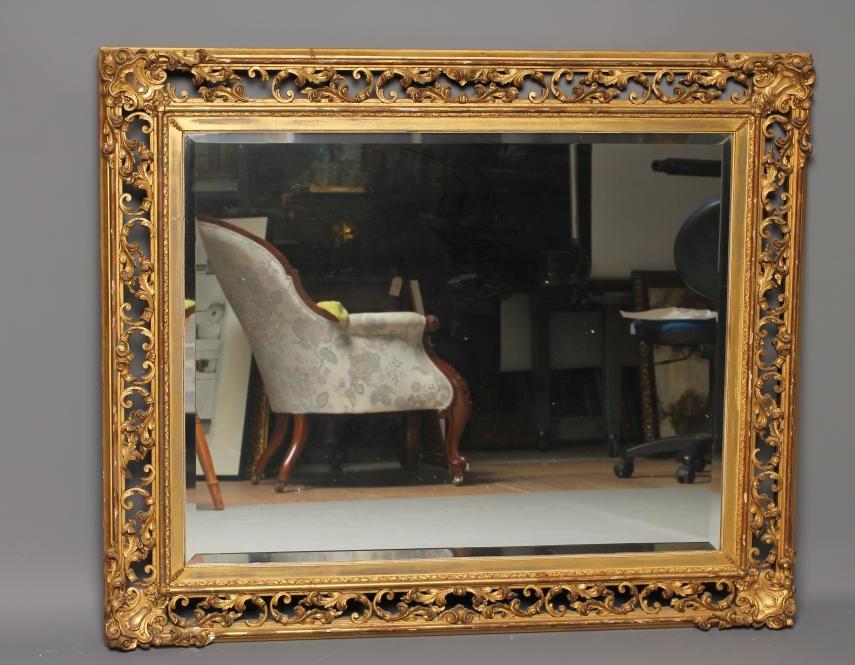 A CARVED AND GILT WOOD WALL MIRROR Image