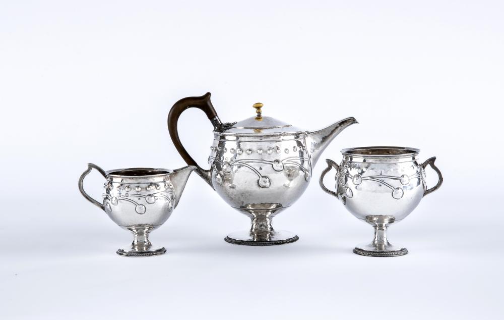 AN EDWARDIAN ARTS AND CRAFTS SILVER THREE PIECE TEA SERVICE Image