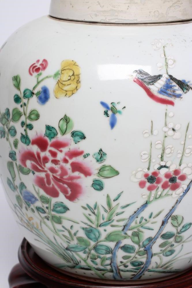 A CHINESE PORCELAIN LARGE JAR AND COVER painted in colours with a finch perched upon a blossoming Image