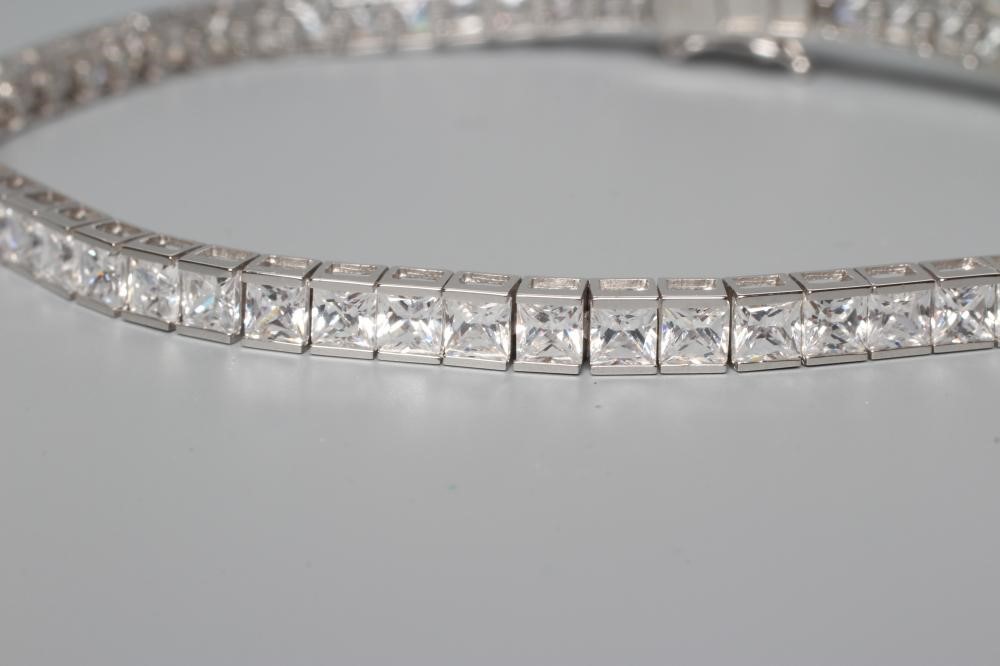 A TENNIS BRACELET, the sixty one cubic zirconia channel set to a plain white frame, stamped 375 Image