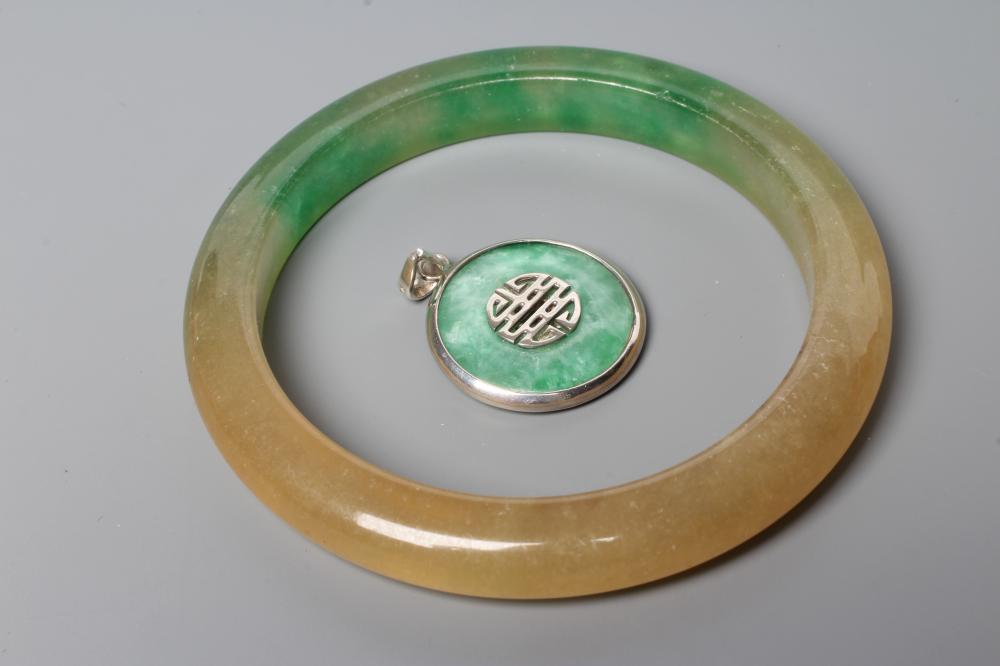 A POLISHED JADE BANGLE of D form, 37g, together with a silver mounted jade Shou pendant, stamped 925 Image