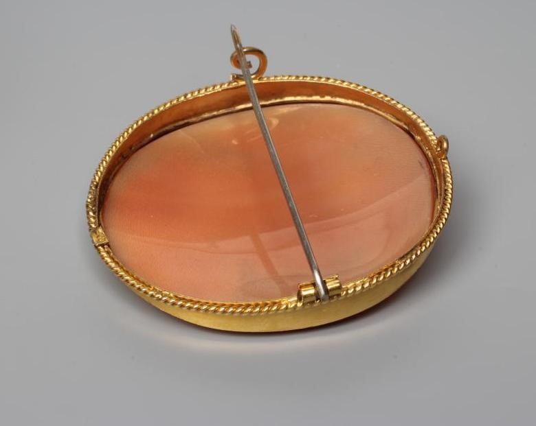 A SHELL CAMEO BROOCH carved with the head and shoulders of a young lady with flowers in her curled Image