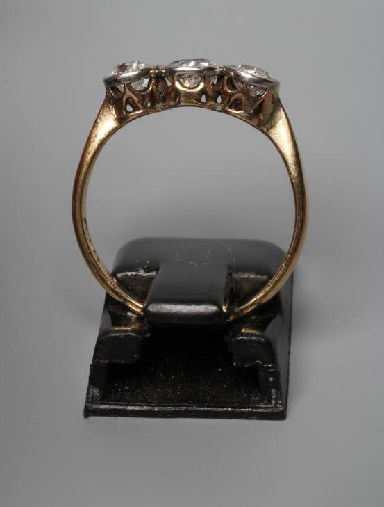 A THREE STONE DIAMOND RING, the old cut stones collet set to a plain shank stamped 18ct, size N Image