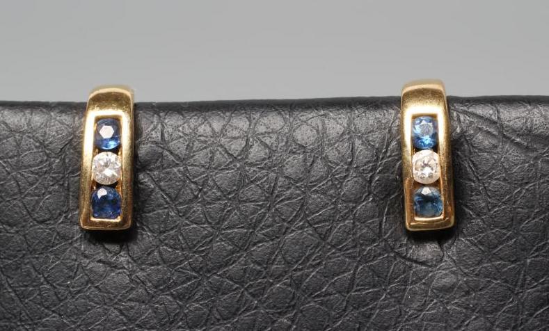A SMALL PAIR OF SAPPHIRE AND DIAMOND HALF HOOP EAR STUDS, channel set with a diamond flanked by two Image