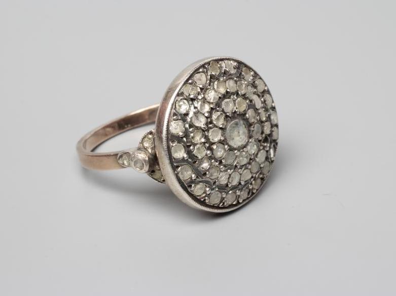 A DIAMOND TARGET RING, the circular panel point set with numerous mix cut (mostly rose cut) stones Image