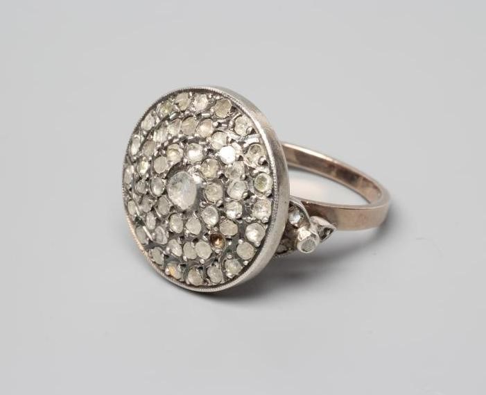 A DIAMOND TARGET RING, the circular panel point set with numerous mix cut (mostly rose cut) stones Image