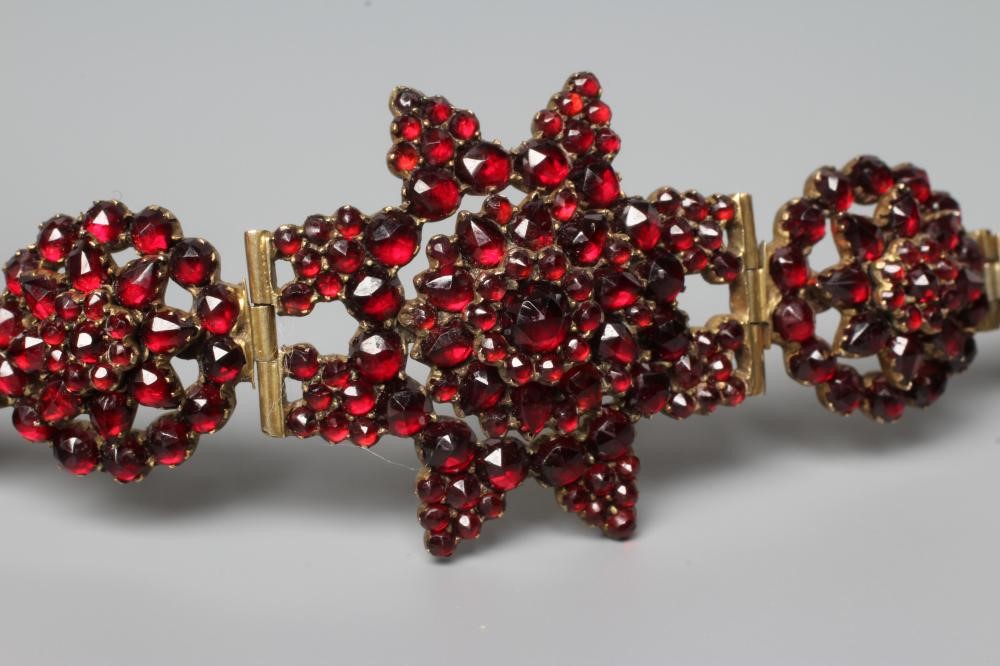 A LATE XIX CENTURY BOHEMIAN GARNET BRACELET, the central star panel hinged to smaller clusters on a Image