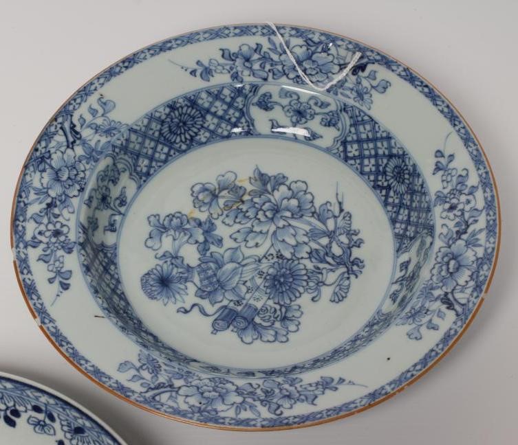 TWO CHINESE PORCELAIN SAUCER DISHES painted in underglaze blue with a flower spray within a diapered Image