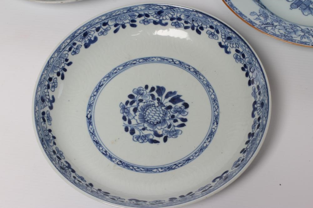 TWO CHINESE PORCELAIN SAUCER DISHES painted in underglaze blue with a flower spray within a diapered Image