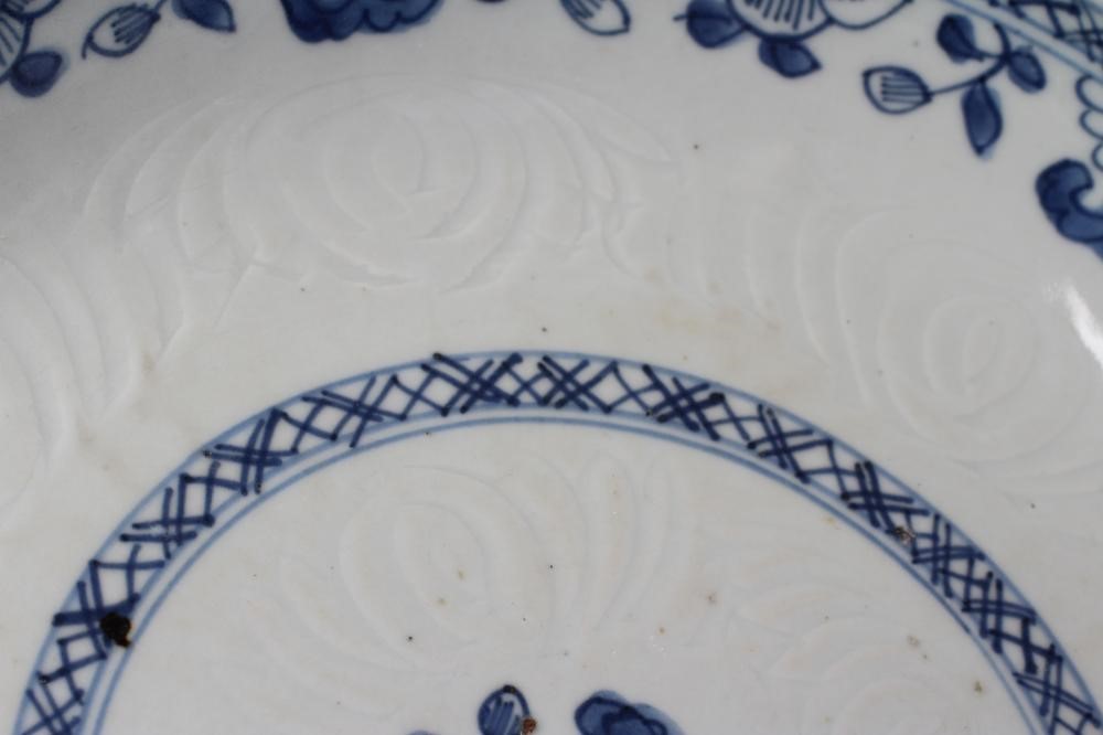 TWO CHINESE PORCELAIN SAUCER DISHES painted in underglaze blue with a flower spray within a diapered Image