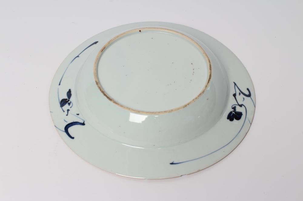 TWO CHINESE PORCELAIN SAUCER DISHES painted in underglaze blue with a flower spray within a diapered Image