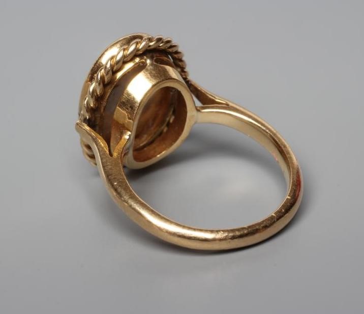AN OPAL DRESS RING, the oval cabochon polished stone collet set to a rope twist mount and plain Image