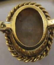 AN OPAL DRESS RING, the oval cabochon polished stone collet set to a rope twist mount and plain Image