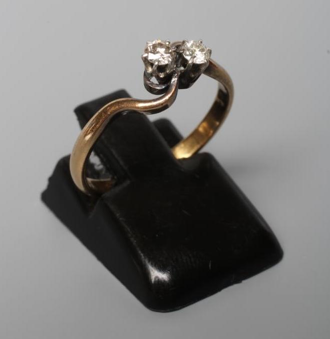 A TWO STONE DIAMOND CROSSOVER RING, the small old brilliant cut stones claw set to a plain shank Image