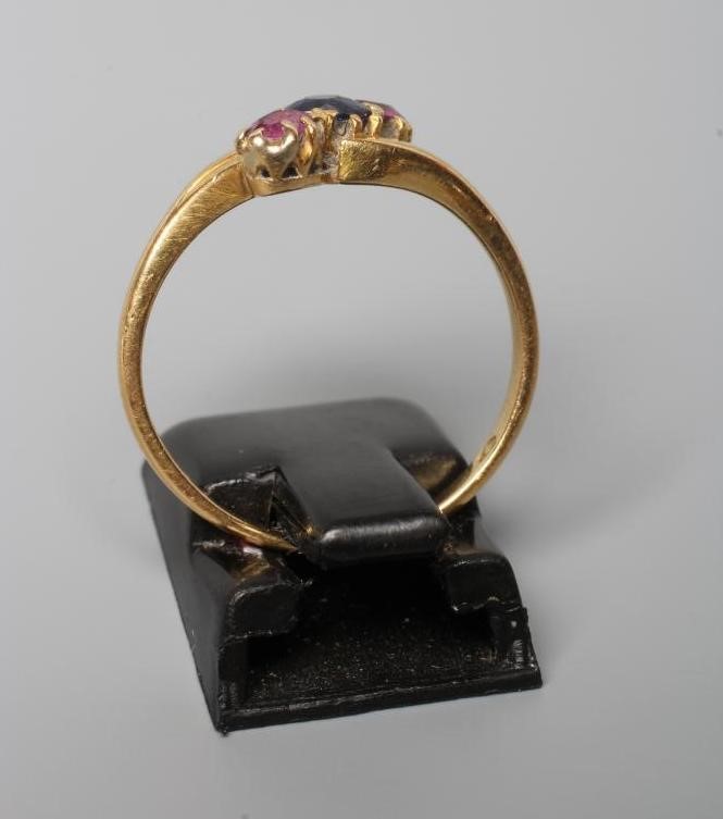 A SAPPHIRE AND GARNET THREE STONE CROSSOVER RING Image