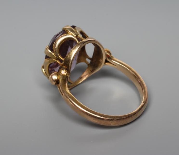 AN AMETHYST DRESS RING, the oval facet cut stone claw set to bead shoulders and a plain shank Image