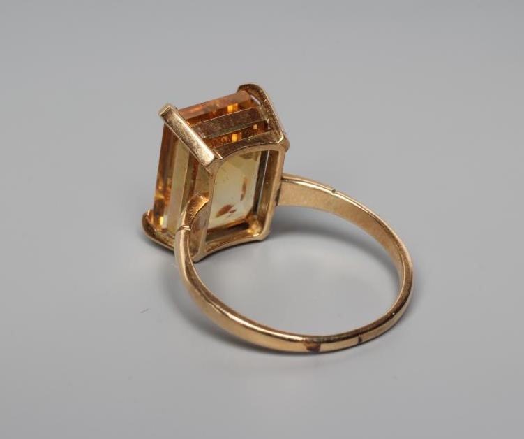 A CITRINE COCKTAIL RING, the rectangular cut stone claw set to reeded shoulders and a plain shank Image