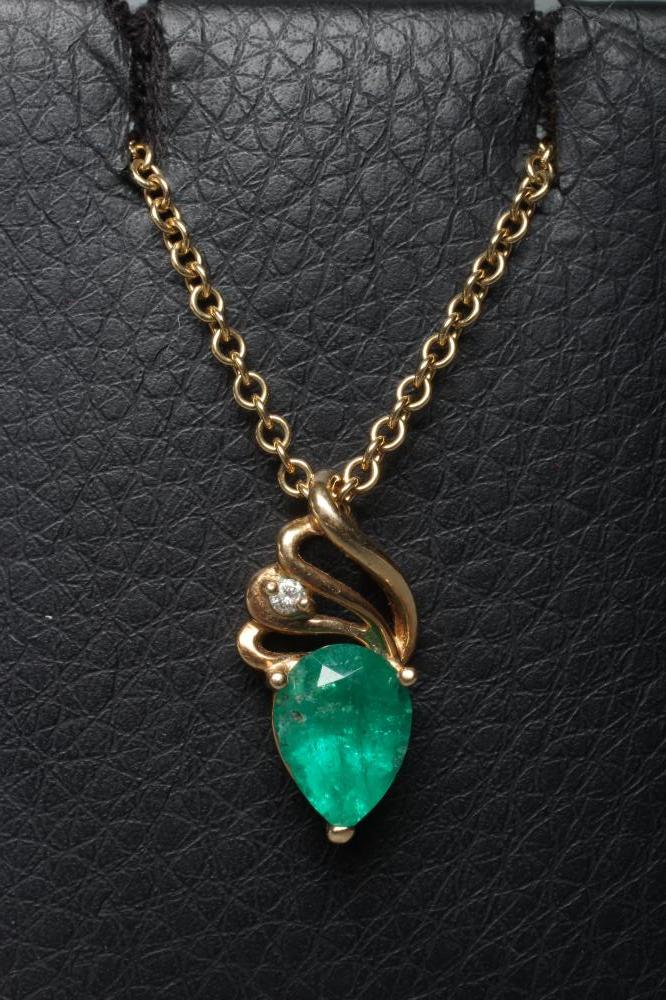 AN EMERALD PENDANT, the pear cut stone claw set to a plain unmarked frame below a triple bale set Image