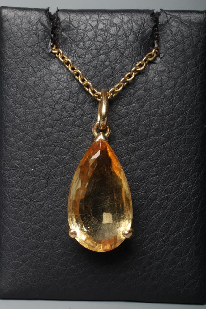 A CITRINE PENDANT, the pear cut stone claw set to a plain frame stamped 14K, on a chain stamped 9ct Image