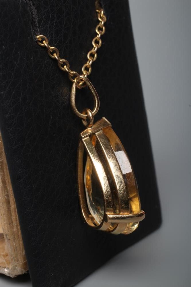 A CITRINE PENDANT, the pear cut stone claw set to a plain frame stamped 14K, on a chain stamped 9ct Image
