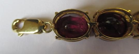 A GARNET BRACELET, the sixteen oval facet cut stones claw set to a plain frame with lobster clasp Image