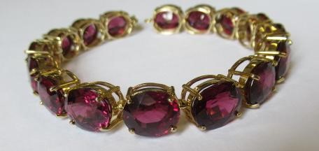 A GARNET BRACELET, the sixteen oval facet cut stones claw set to a plain frame with lobster clasp Image