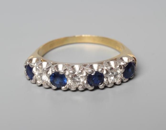 A SAPPHIRE AND DIAMOND HALF HOOP RING, the four sapphires and three brilliant cut diamonds point set Image