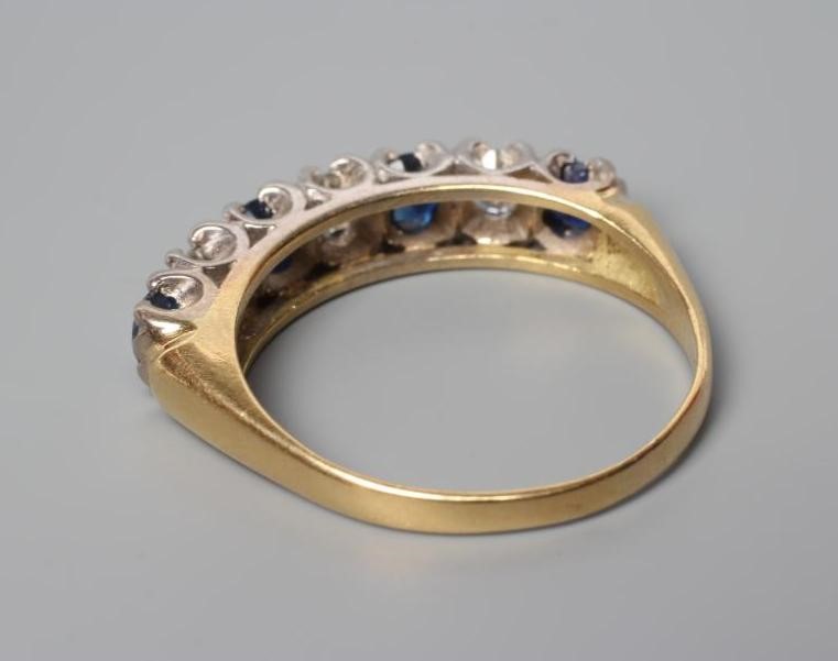 A SAPPHIRE AND DIAMOND HALF HOOP RING, the four sapphires and three brilliant cut diamonds point set Image