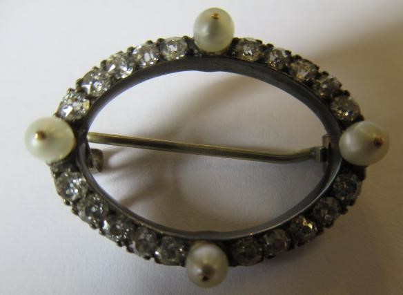 A LATE VICTORIAN DIAMOND AND PEARL OVAL BROOCH, the four peg set pearls with twenty small diamonds Image